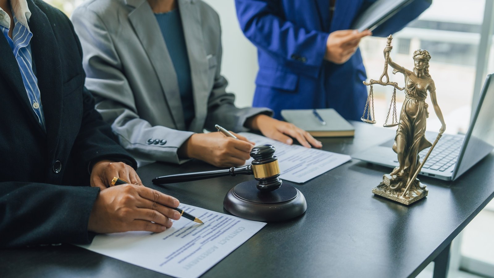 Business lawyer team working with law firms contracts in working room.